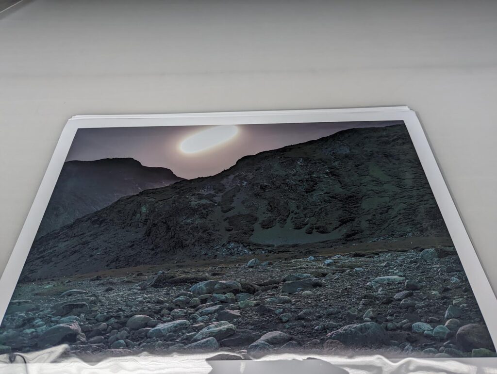 Arctic Edge, Photography Exhibition at Scandinavia House NYC, Night Landscape Photos of Greenland, By Steve Giovinco Print on Table, Moon Rising Over Rocky Cliff